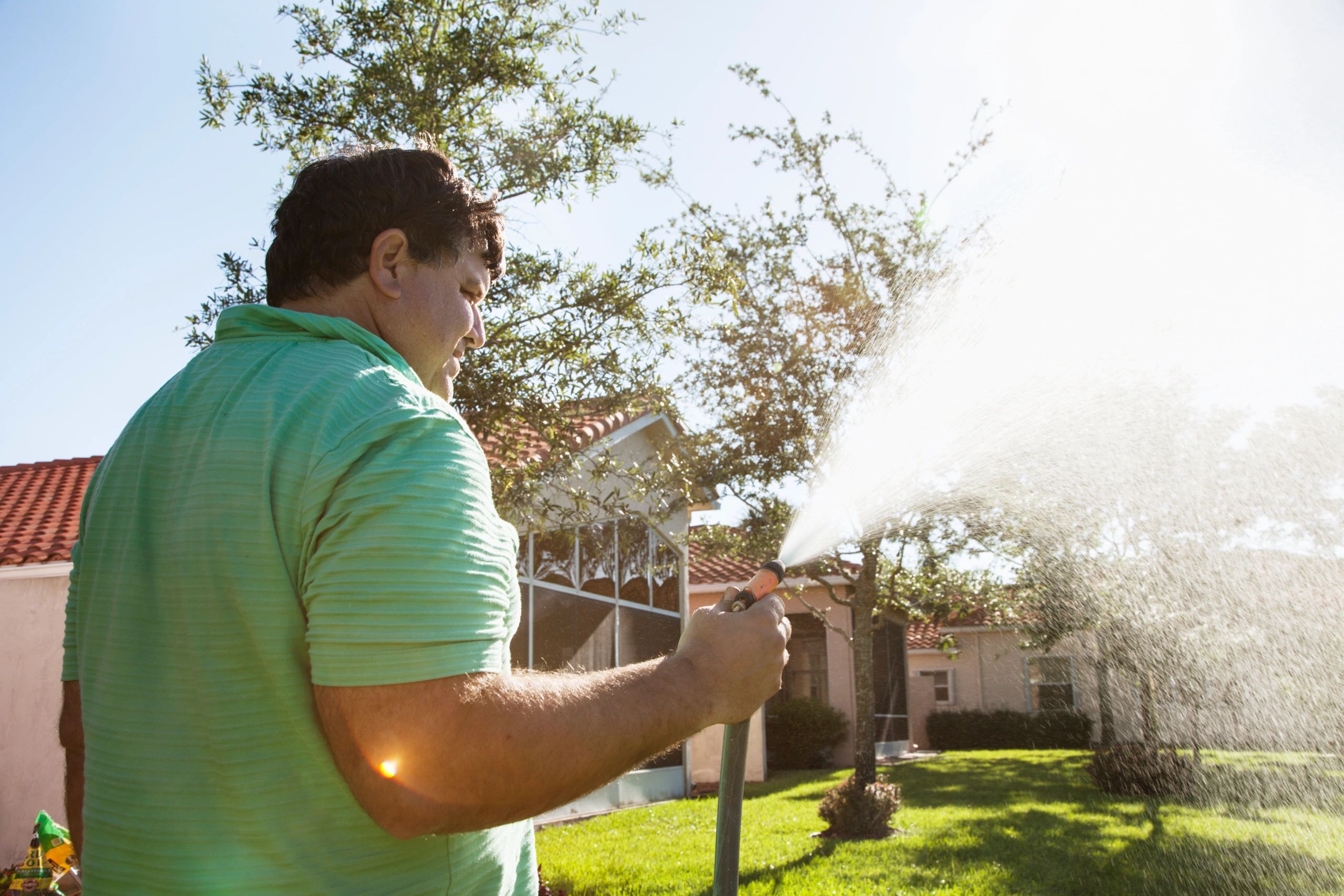Technician watering a garden in a tropical climate